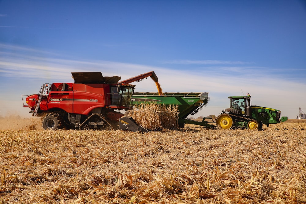 a red tractor and a green tractor in a field