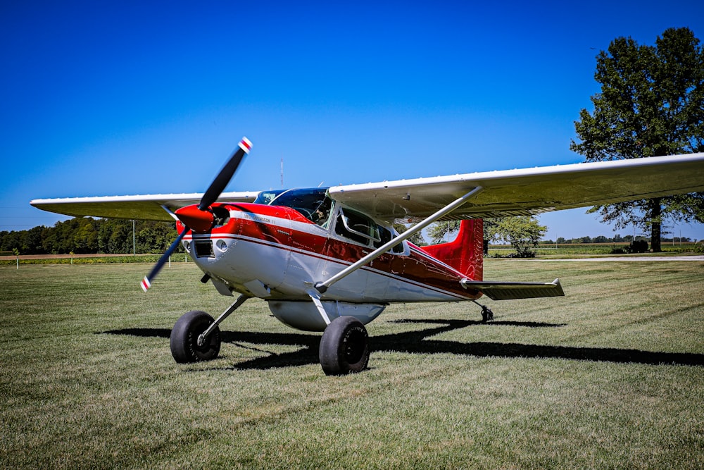 a small airplane sitting on top of a lush green field