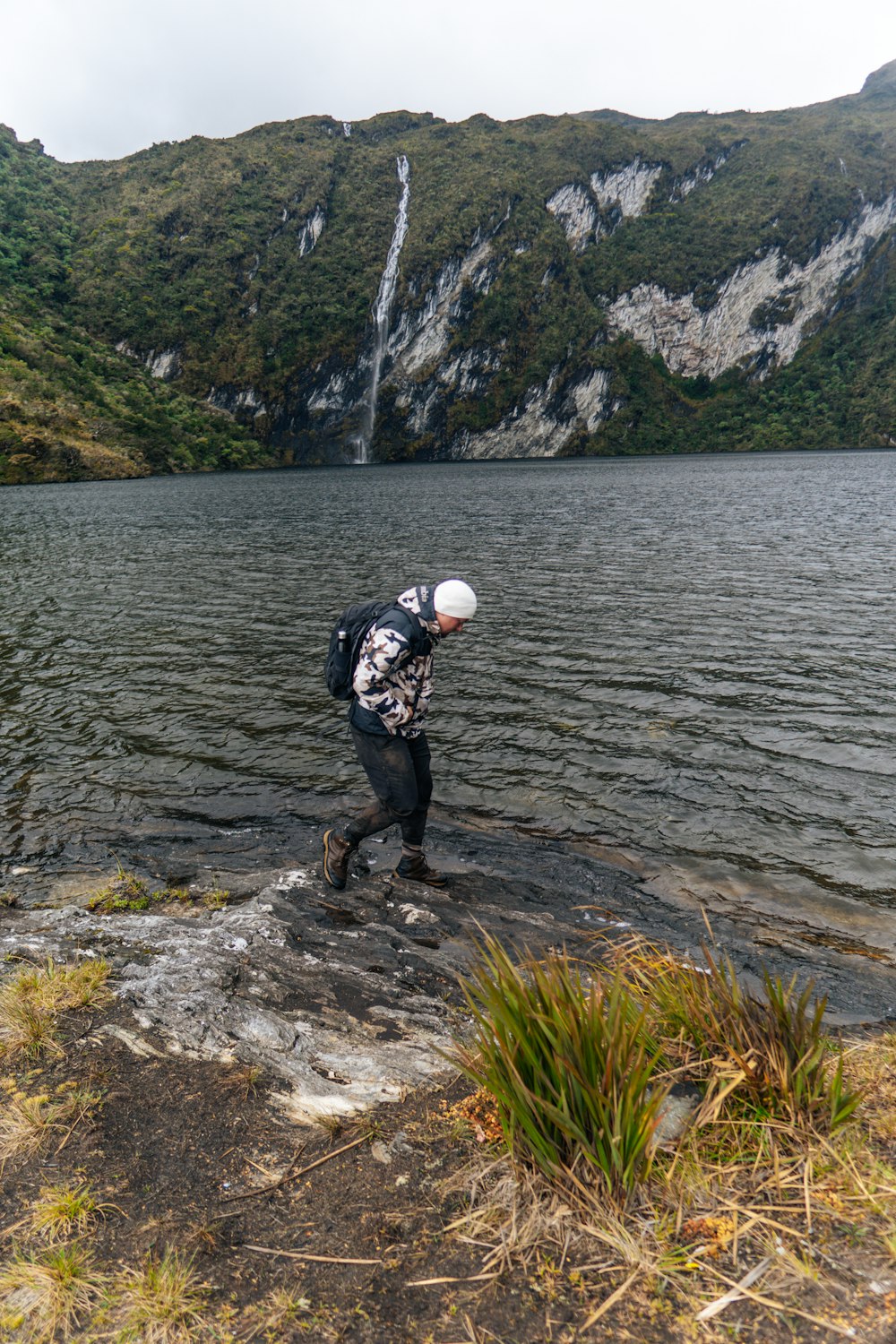 a man standing on a rock near a body of water