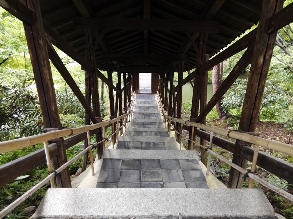 a walkway with stone steps leading to a covered area
