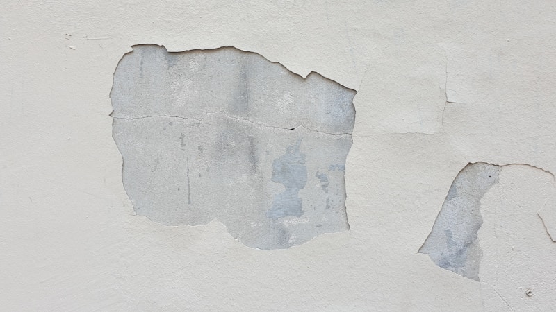 Close up of damaged wall with plaster hole