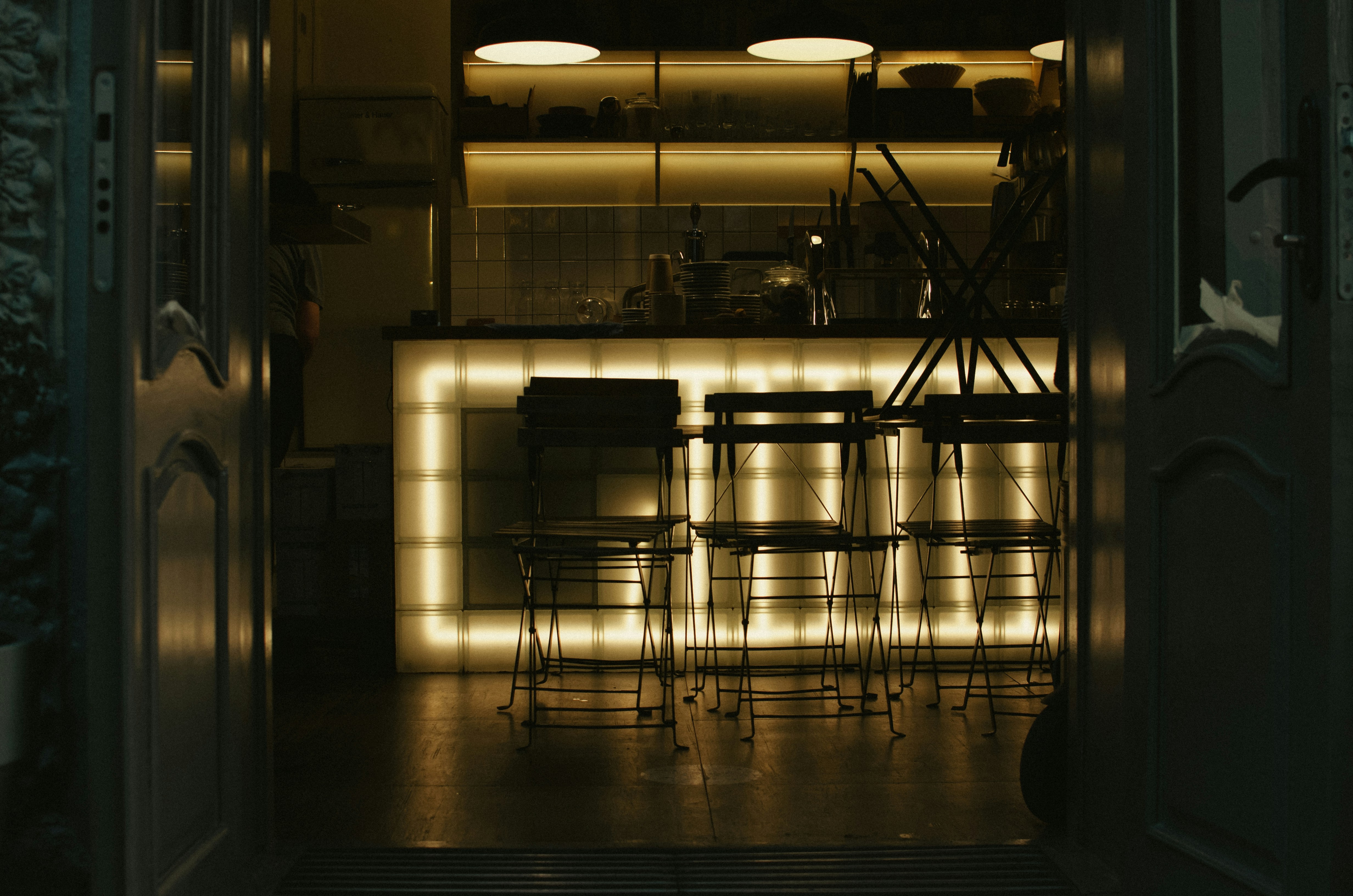 a dimly lit room with chairs and a bar