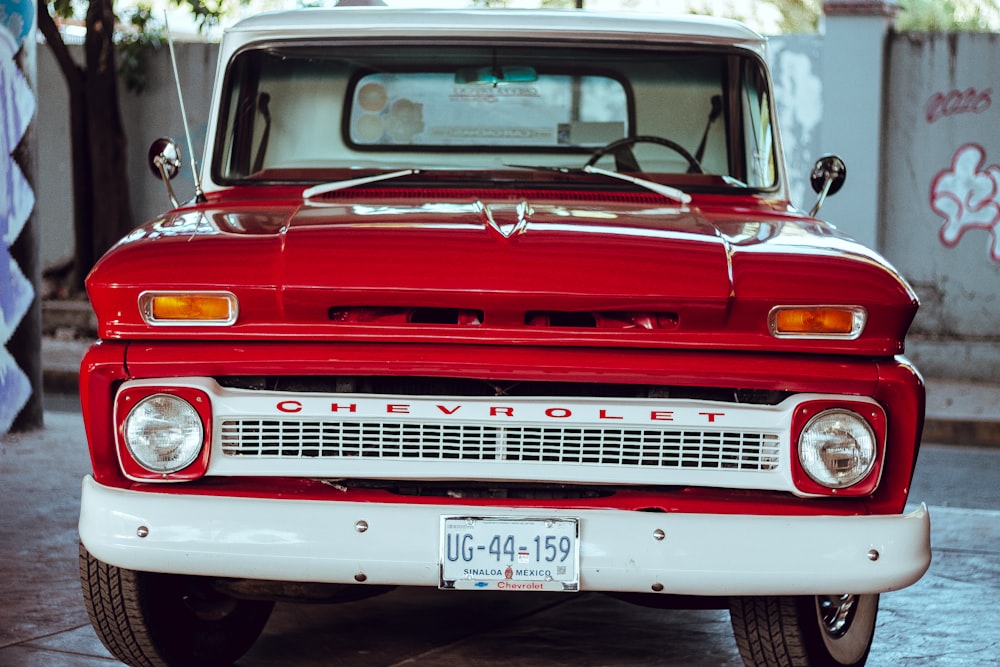 a red and white chevrolet truck parked in a garage