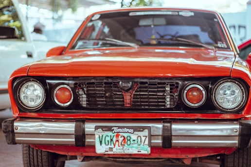a red car parked in a parking lot next to other cars