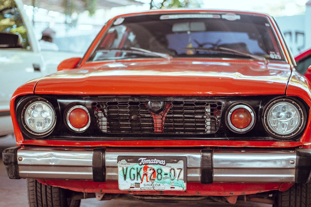 a red car parked in a parking lot next to other cars