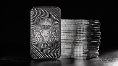 a lighter with a lion on it next to stacks of coins