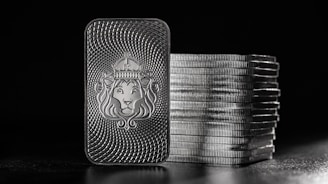 a lighter with a lion on it next to stacks of coins