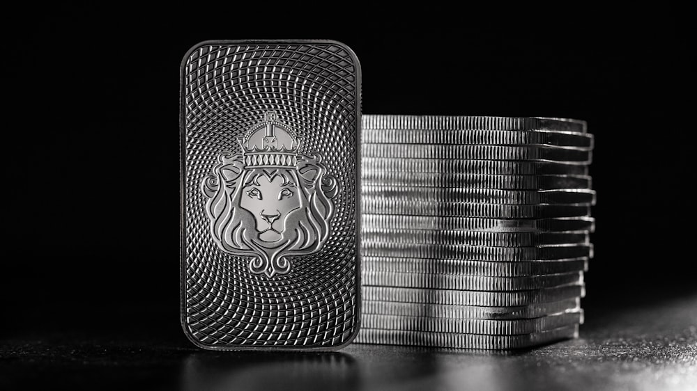 a lighter with a lion on it next to stacks of coins
