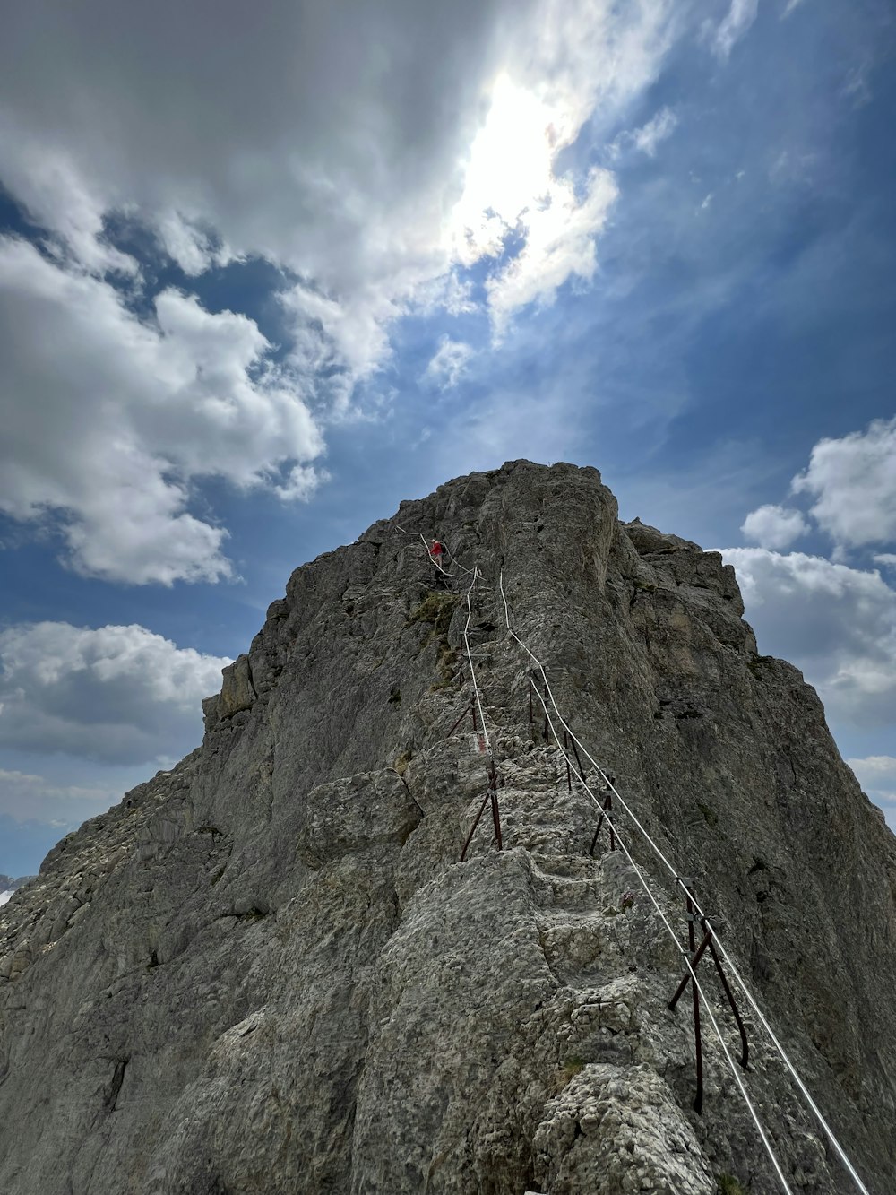 Un hombre subiendo una montaña con una escalera