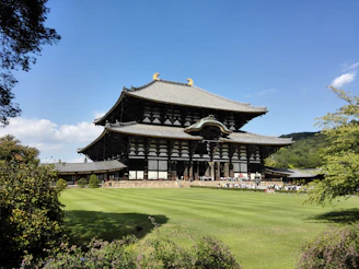 Sunlit seminary courtyard with soft greenery and traditional Karnataka architecture in the background.