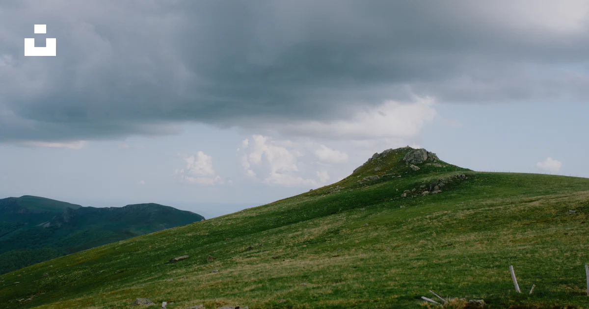 Small Hill Rise A grassy hill with a small hill in the distance photo – Free Puy mary ...