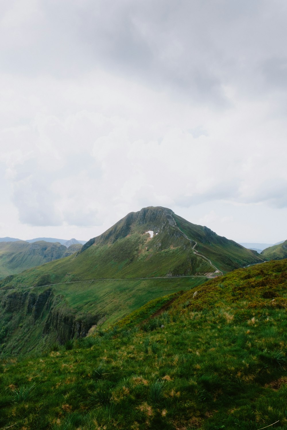 a green mountain with a road going through it