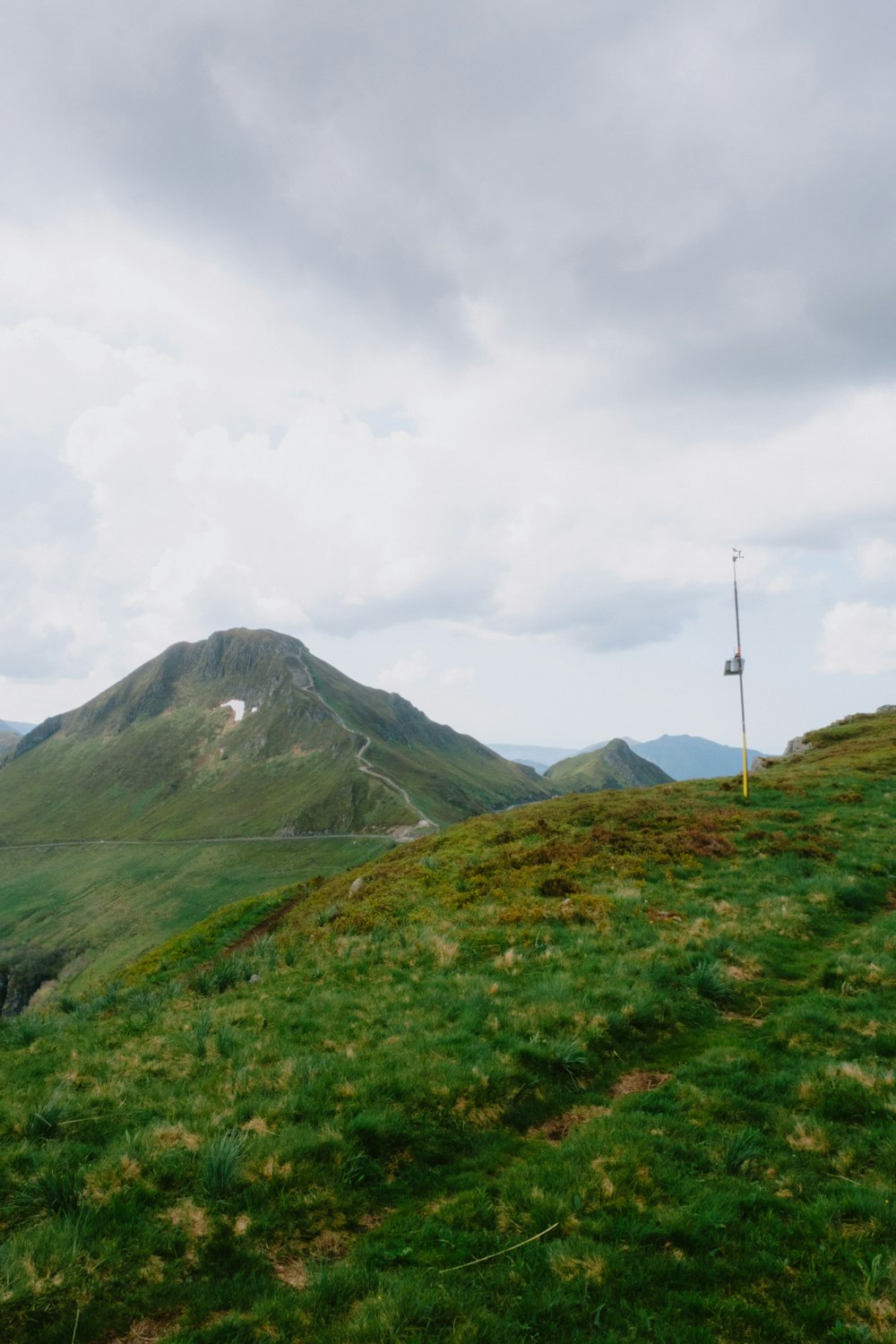 a grassy hill with a flag on top of it