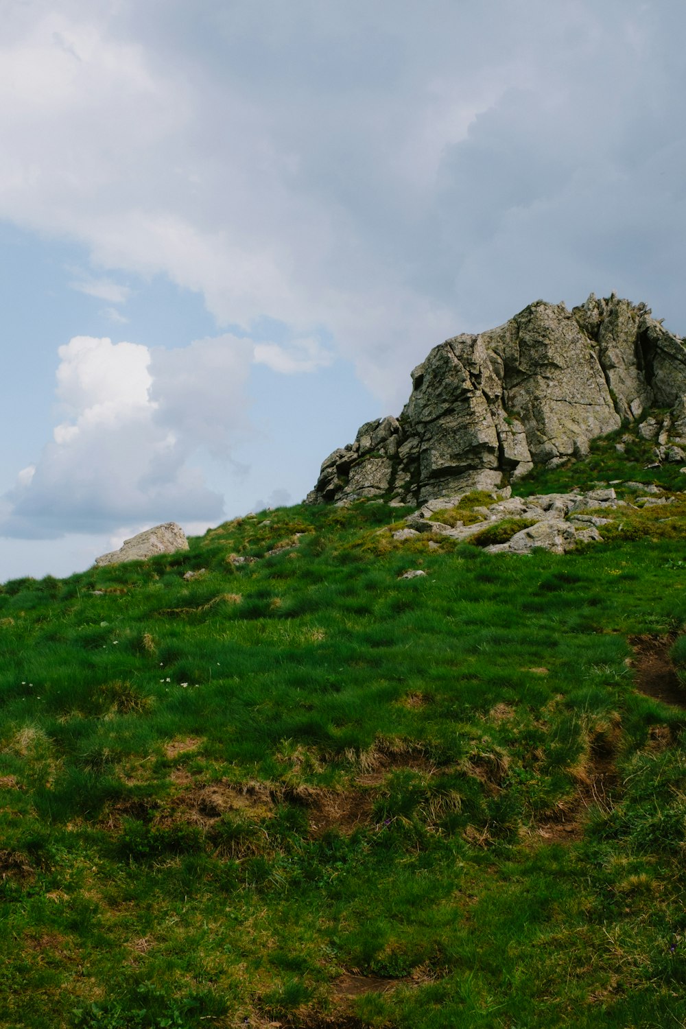 a rocky outcropping on a grassy hill