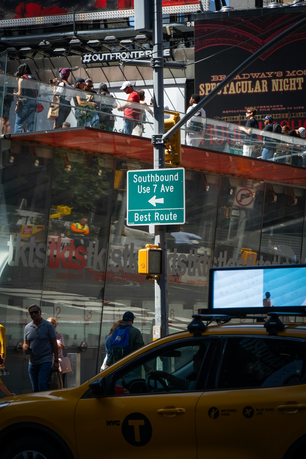 a yellow taxi cab driving down a street next to a tall building