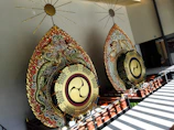 Traditional kendang drums with vibrant painted details, set against a backdrop of bamboo.