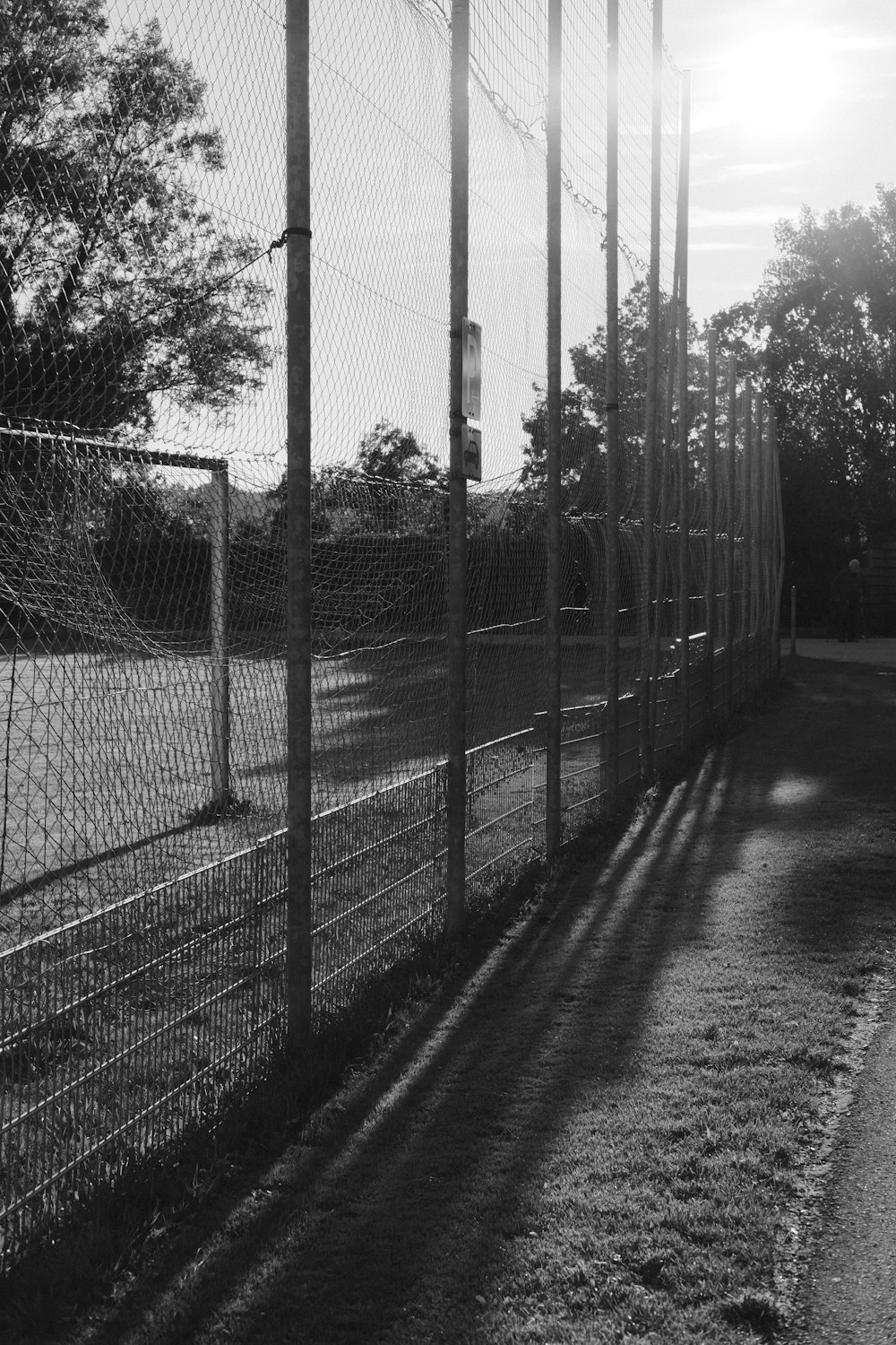 a black and white photo of a chain link fence