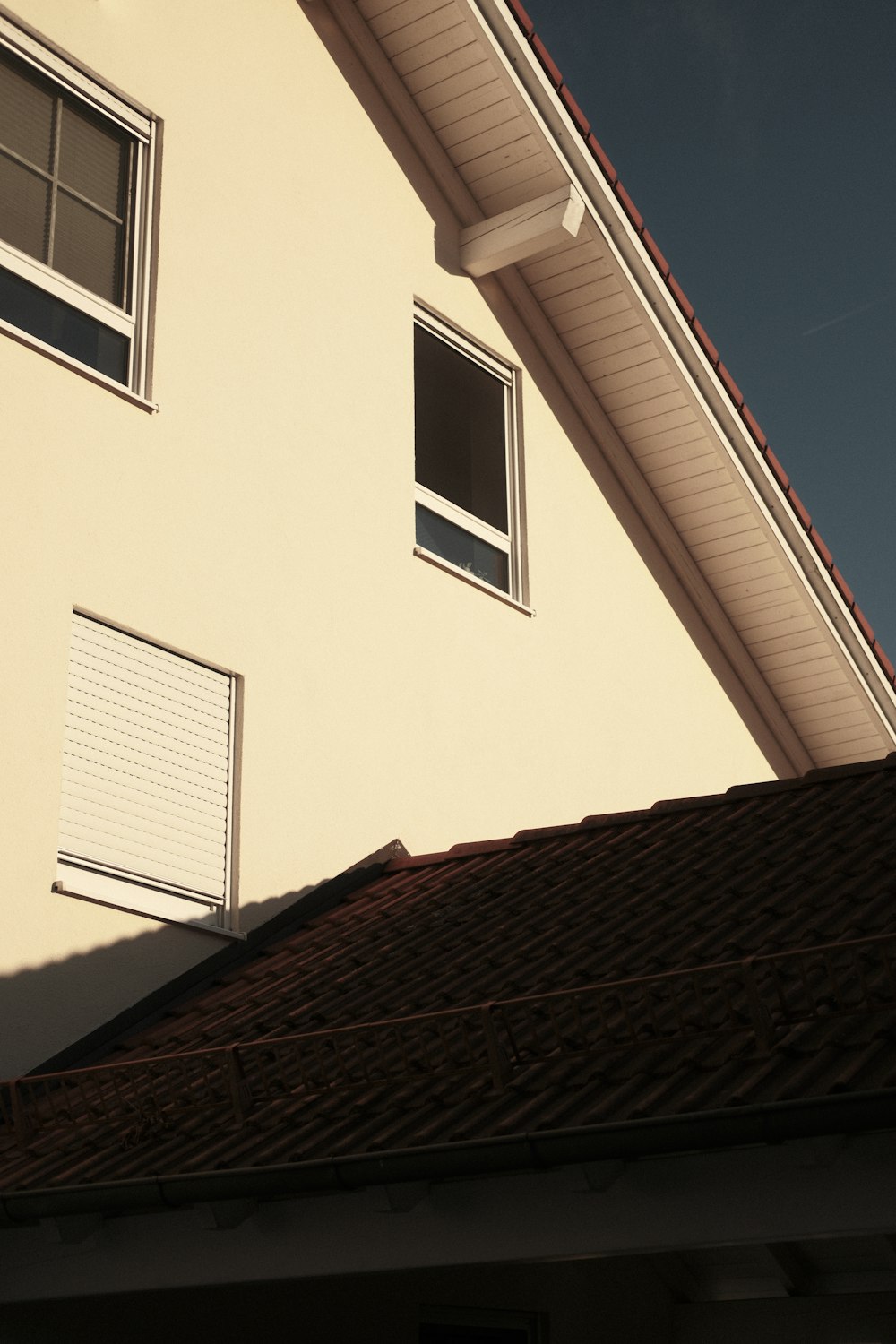 a white house with a red roof and two windows