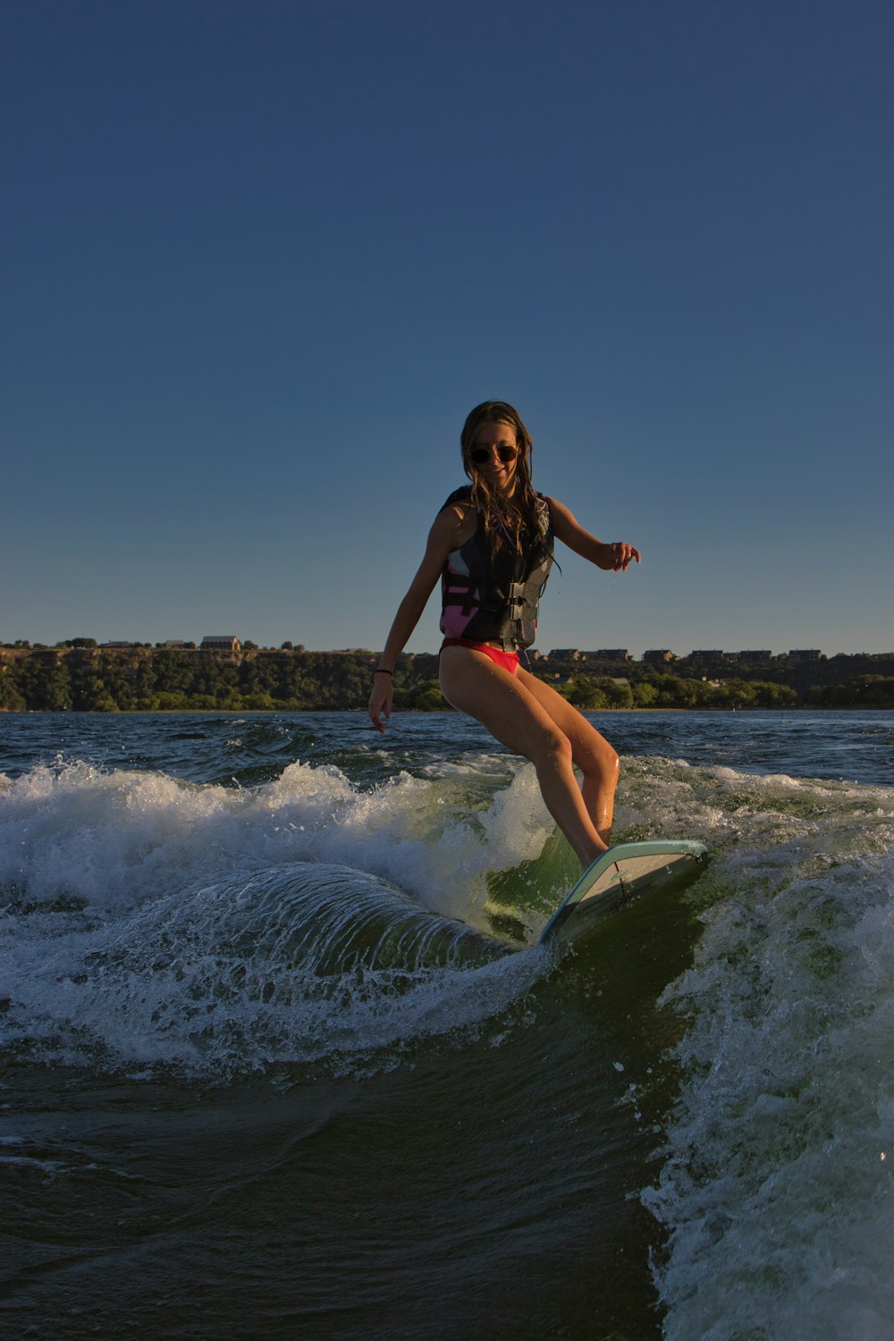 a woman riding a wave on top of a surfboard