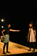 Two students passionately debating on stage.