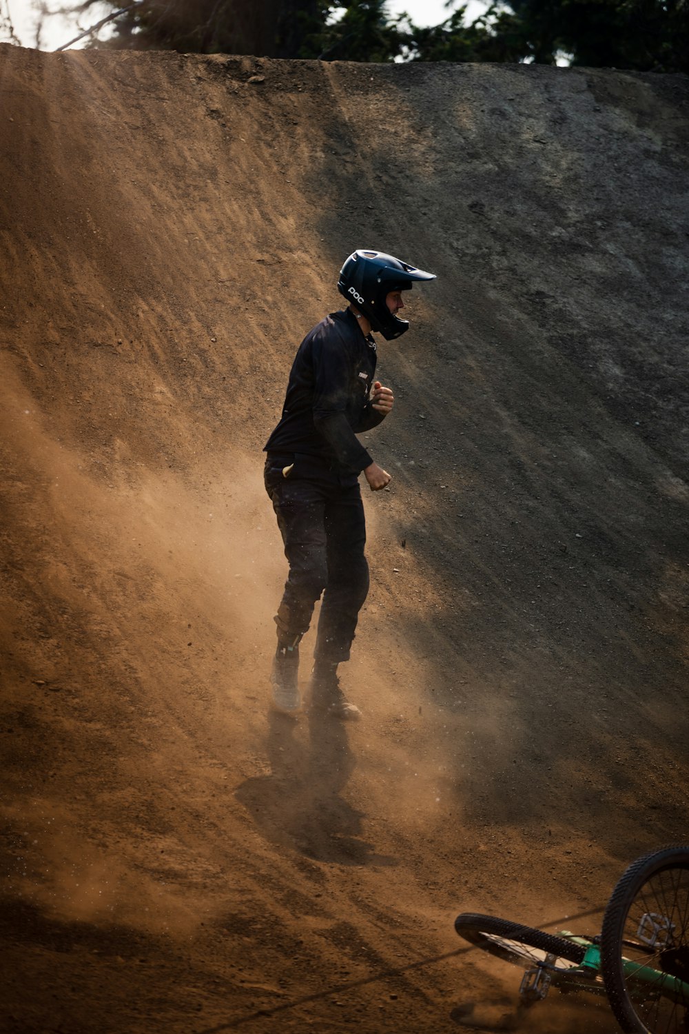 a man riding a bike down a dirt hill