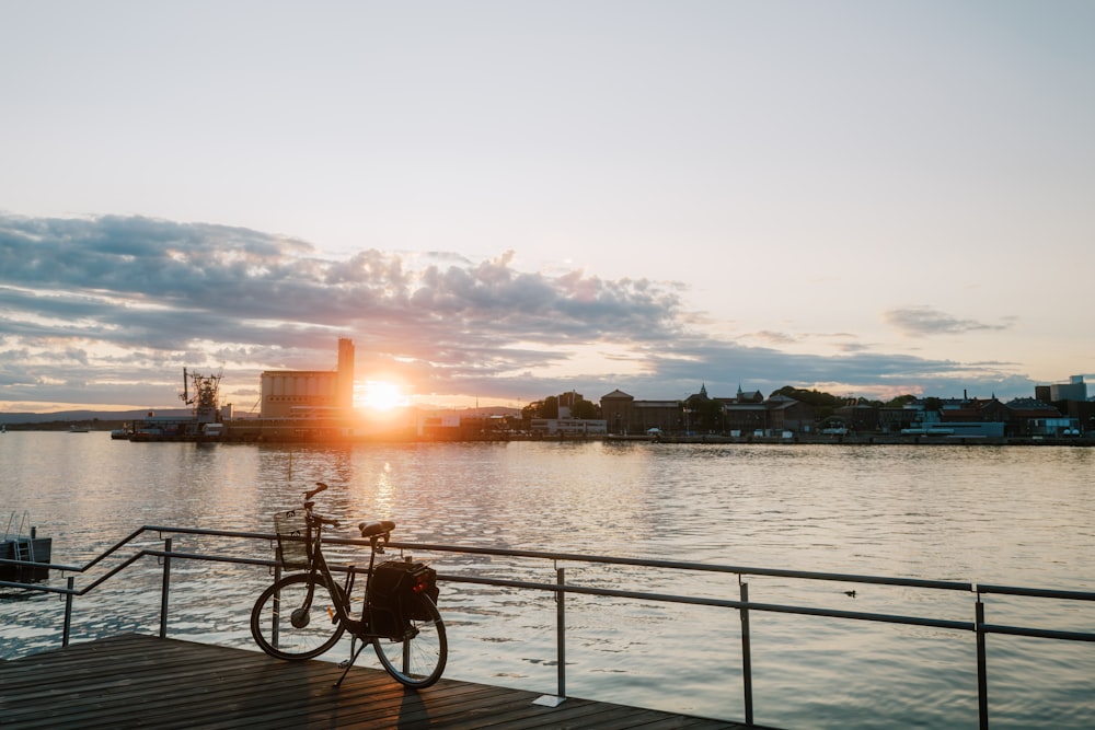 a bike is parked on a dock near the water