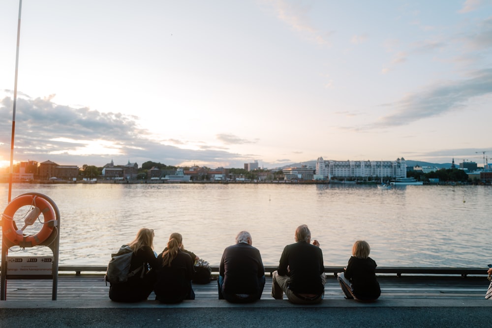 a group of people sitting next to each other on a pier