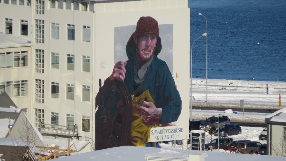 a man standing in front of a building with a picture of a man on it