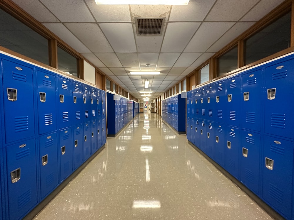 a long hallway lined with blue lockers in a building
