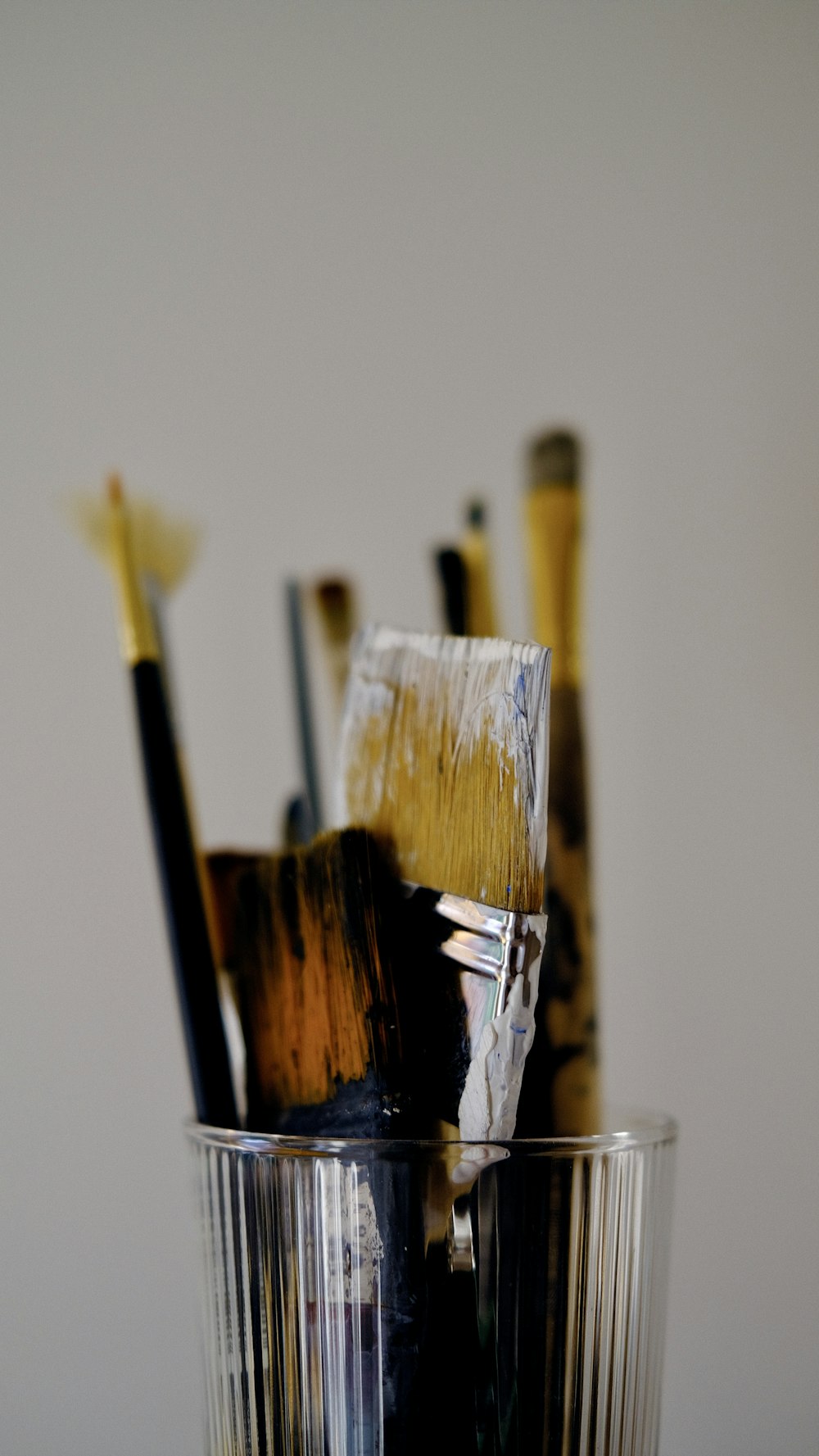 a glass filled with lots of paint brushes