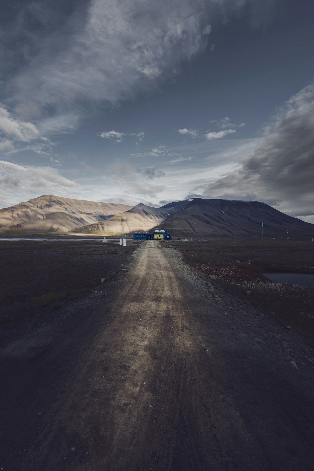 a dirt road with a mountain in the background