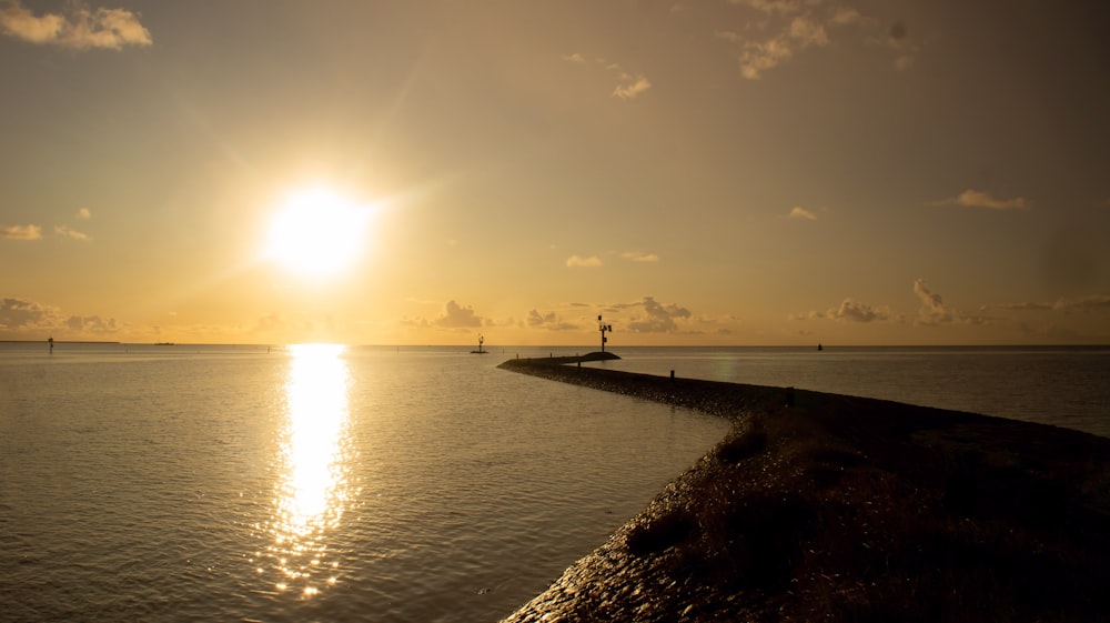 the sun is setting over a body of water