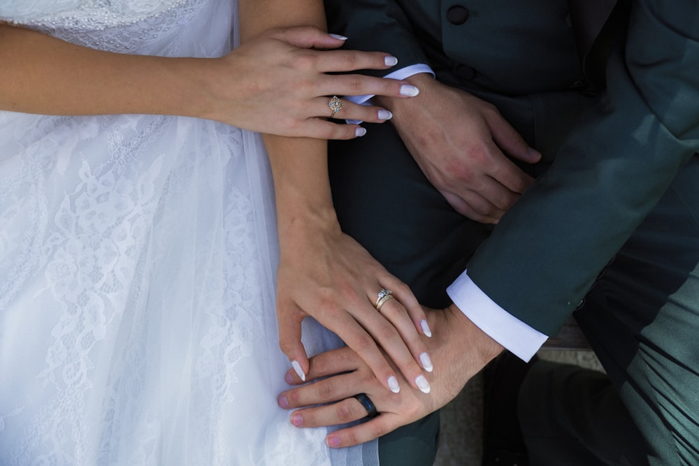 a close up of two people wearing wedding rings