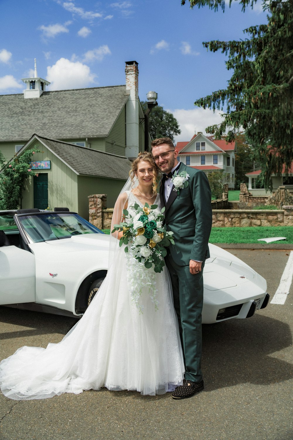 a bride and groom standing in front of a white sports car