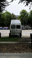 Mobile service van parked beside a caravan at a campsite, tools ready.