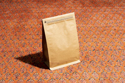 A medium-sized brown paper bag standing upright on a wooden table.