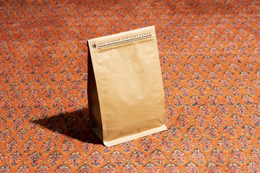 a brown paper bag sitting on top of a carpet