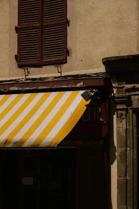 a yellow and white striped awning outside of a building