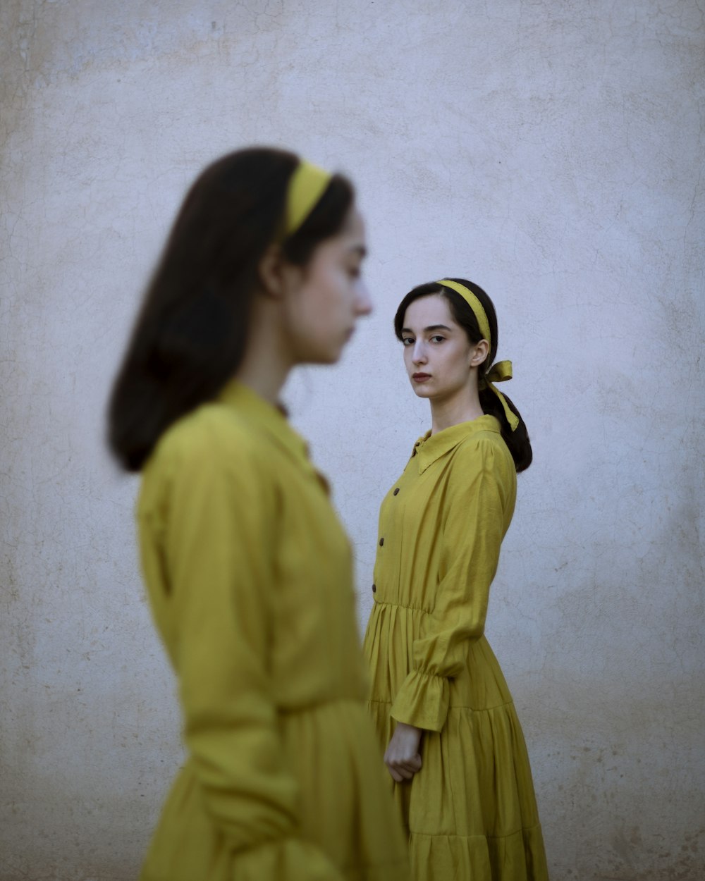 two women in yellow dresses standing next to each other