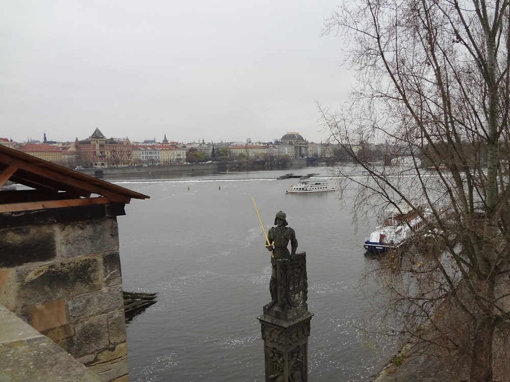 a statue of a man sitting on top of a tower next to a body of