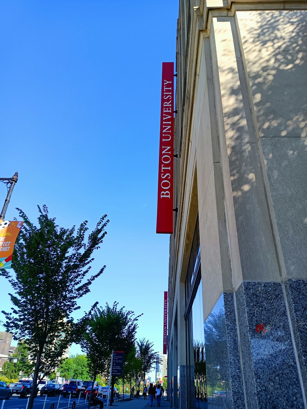 a tall building with a red sign hanging off the side of it