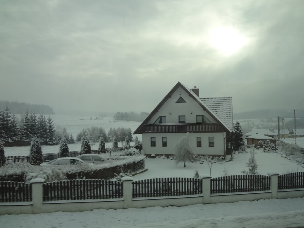 a house in the middle of a snow covered yard