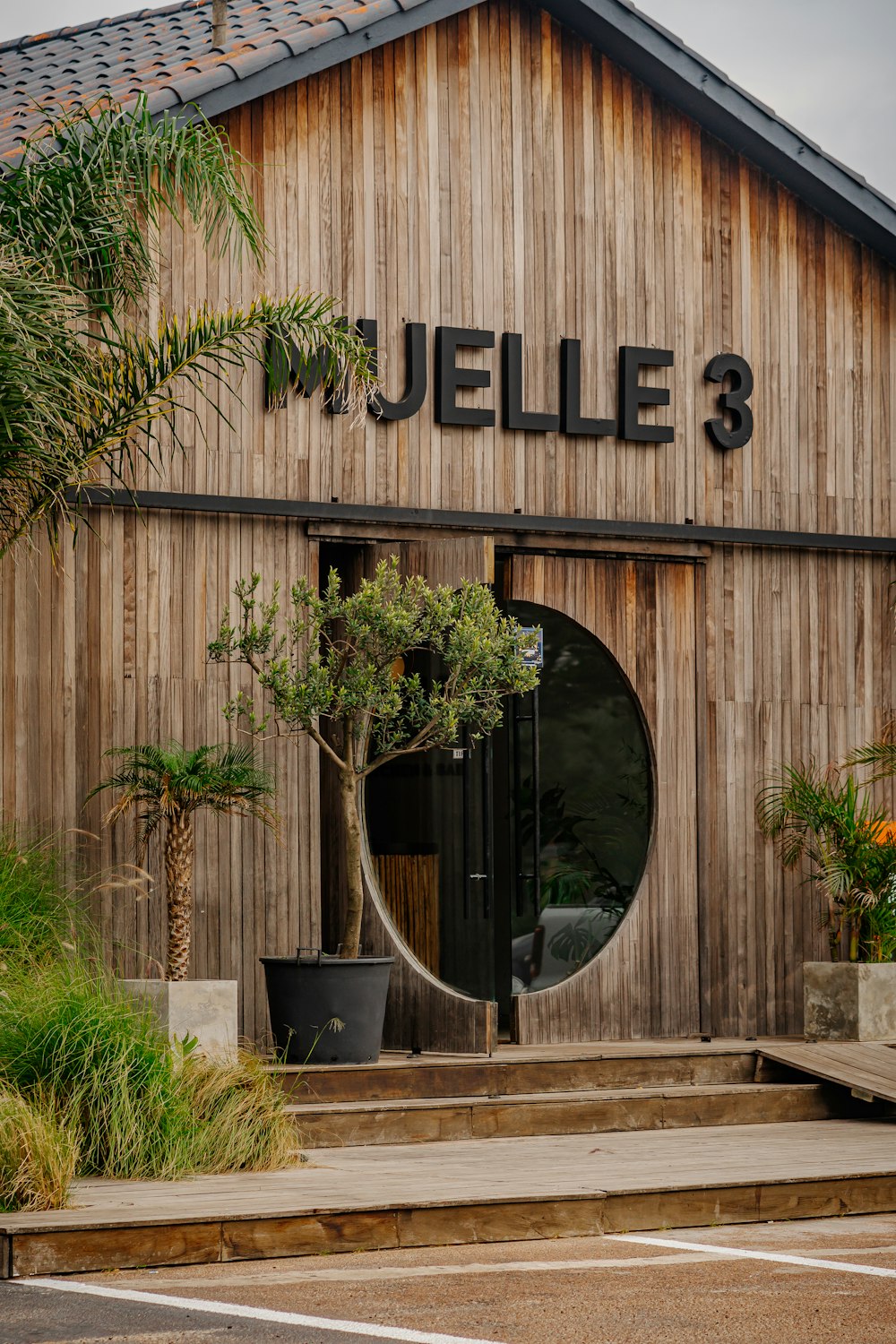 a wooden building with a tree in front of it