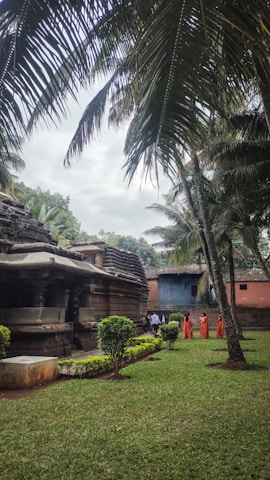 A serene temple courtyard bathed in golden sunlight with devotees walking peacefully.