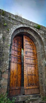 A detailed shot of an old iron gate partially open, hinting at secrets beyond.