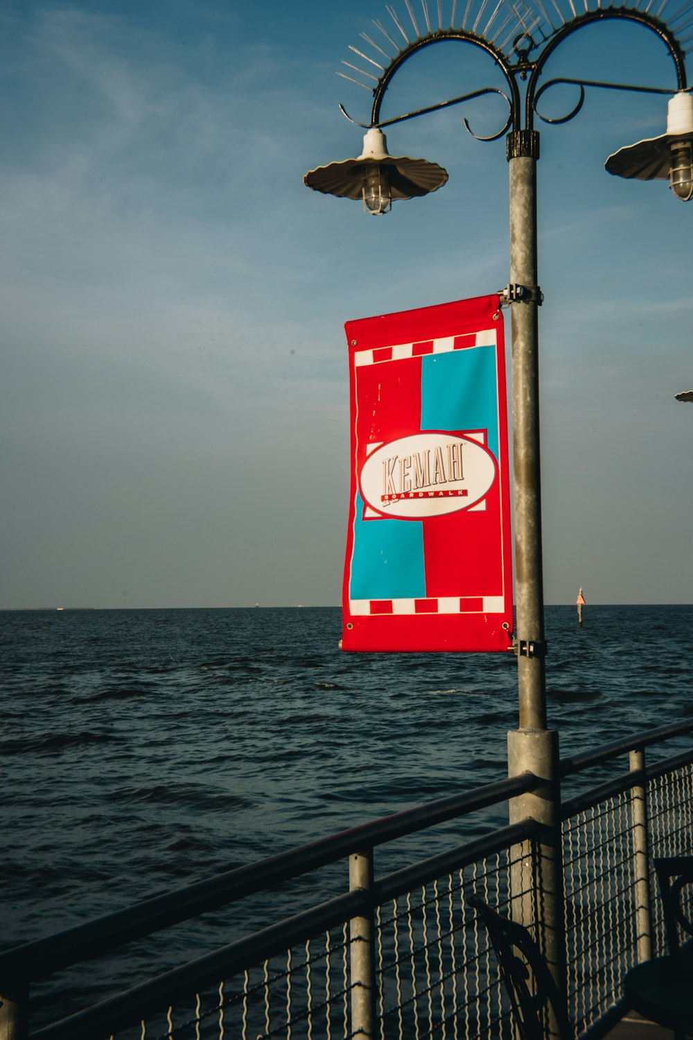 a red and blue sign hanging off the side of a metal pole