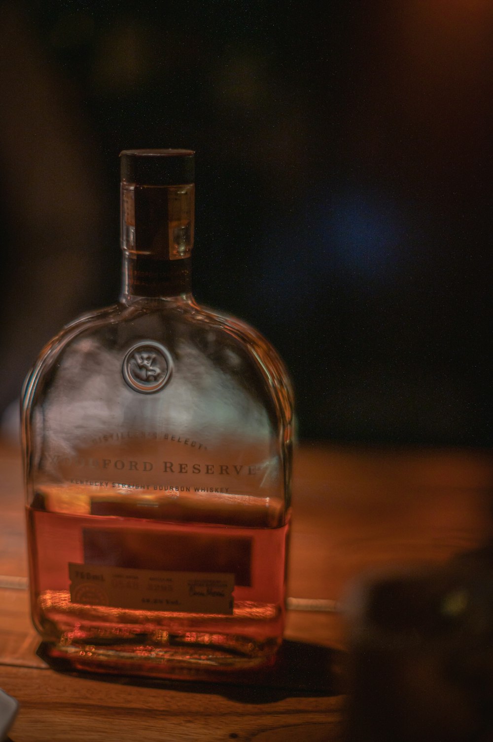 a bottle of whiskey sitting on top of a wooden table