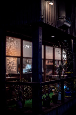 An inviting shot of the cafe’s exterior at dusk, with warm light glowing through the windows and a chalkboard sign announcing today’s specials.