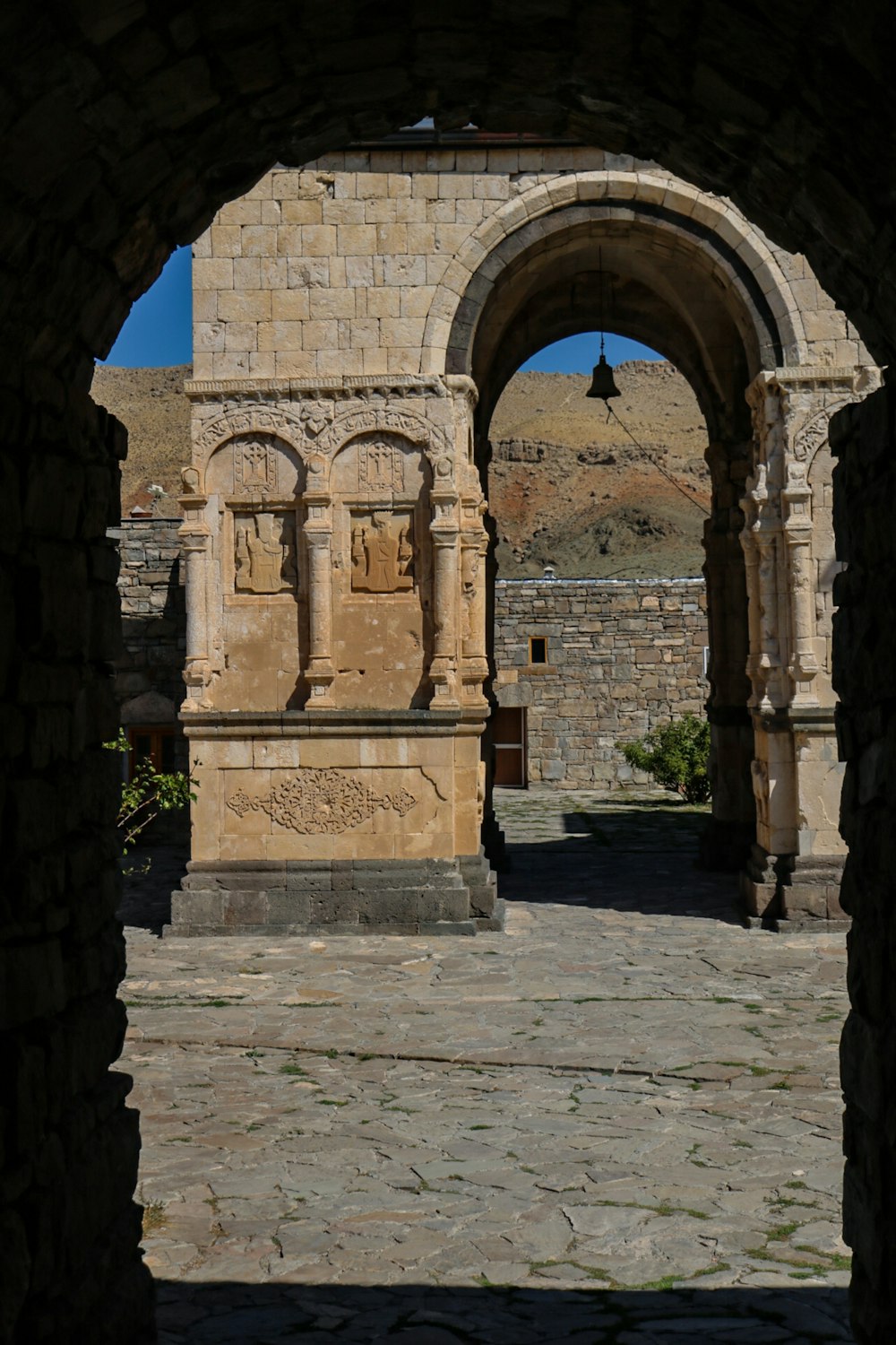 an arch in a stone building with a clock on it