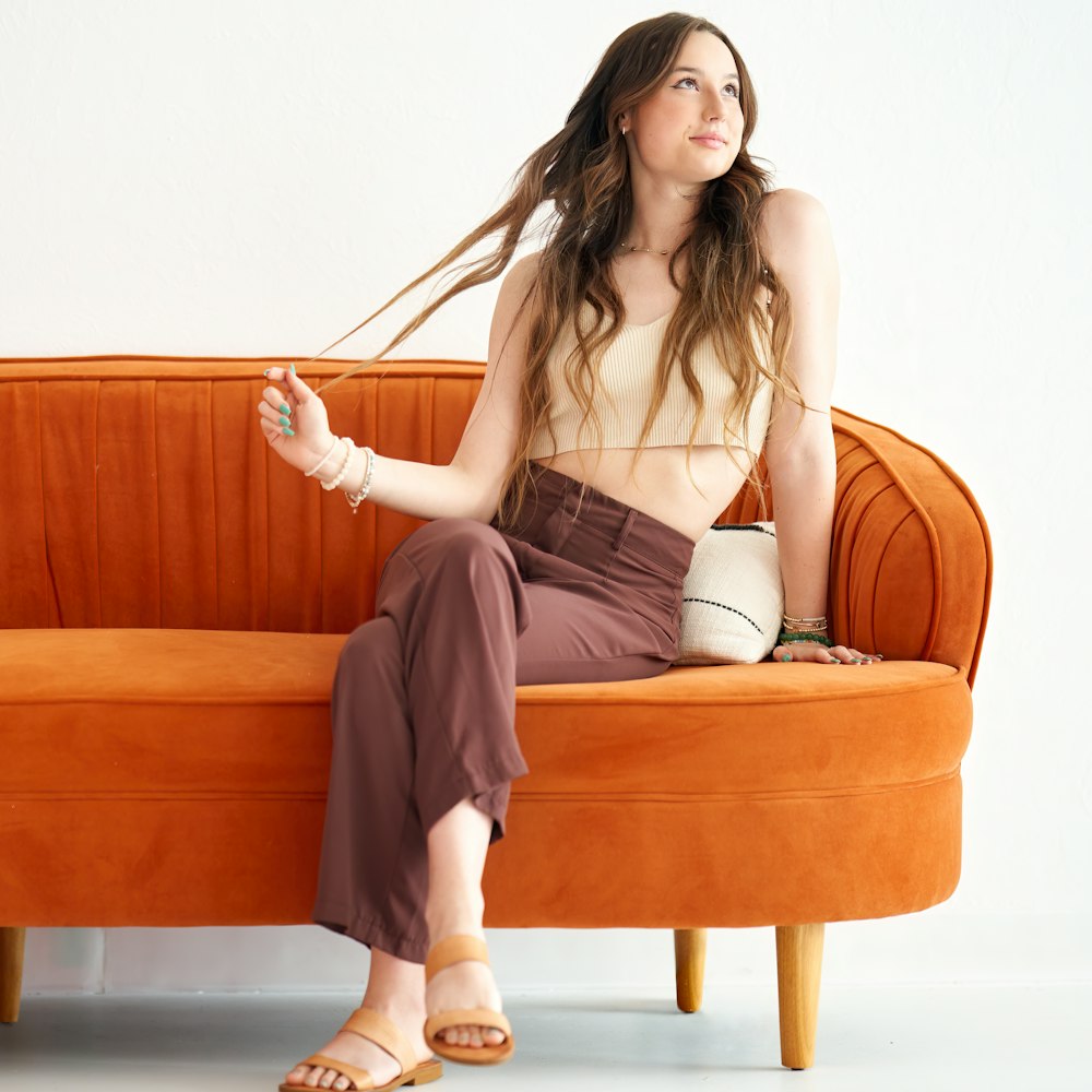a woman with long hair sitting on a couch